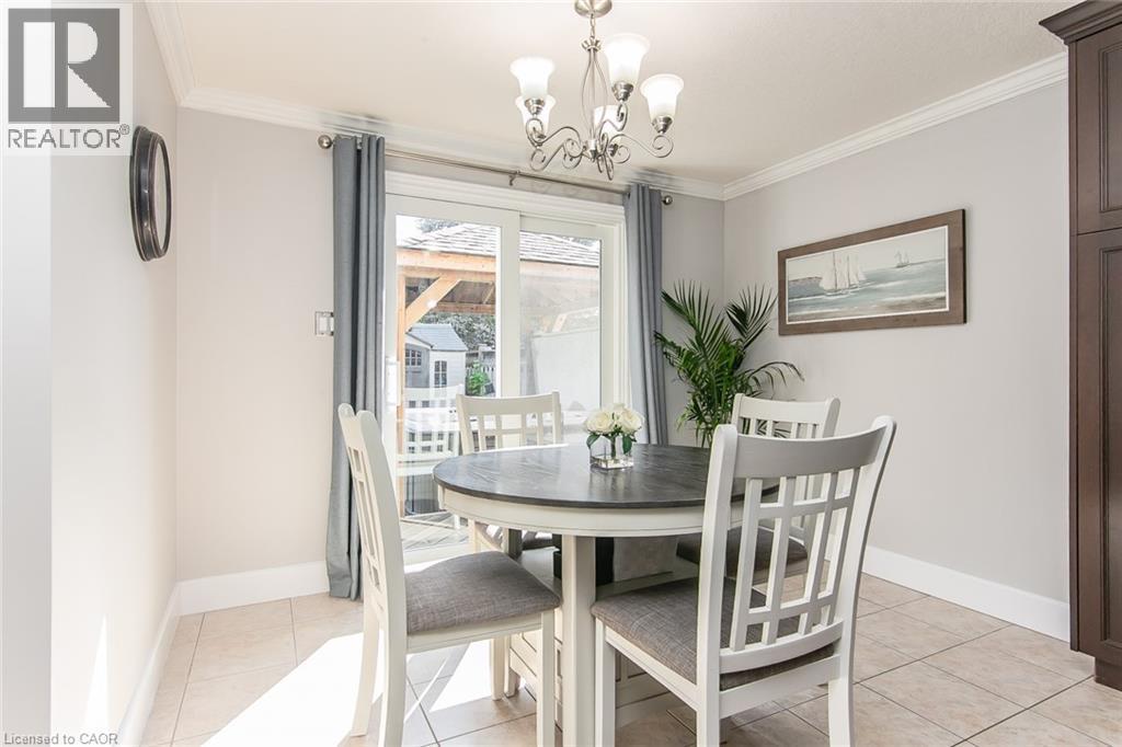 Dining area with tiled flooring, crown molding, and a sliding glass door - 529 Chesapeake Crescent, Waterloo, ON - Indoor Photo Showing Dining Room