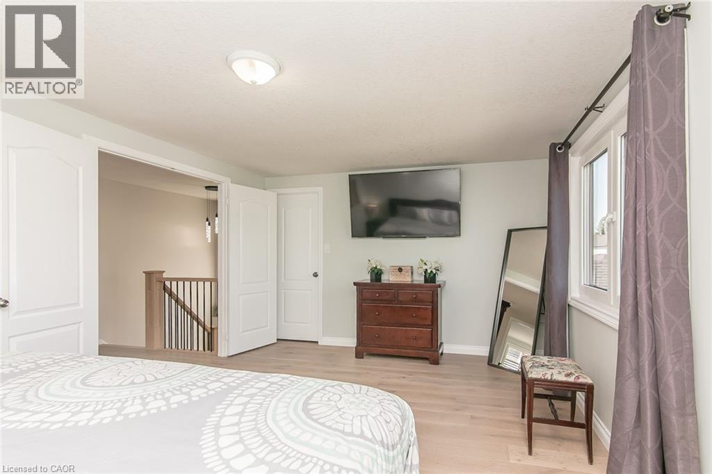 Spacious room featuring wood-finish flooring, light grey wall tones, and a double-door entry - 529 Chesapeake Crescent, Waterloo, ON - Indoor Photo Showing Bedroom