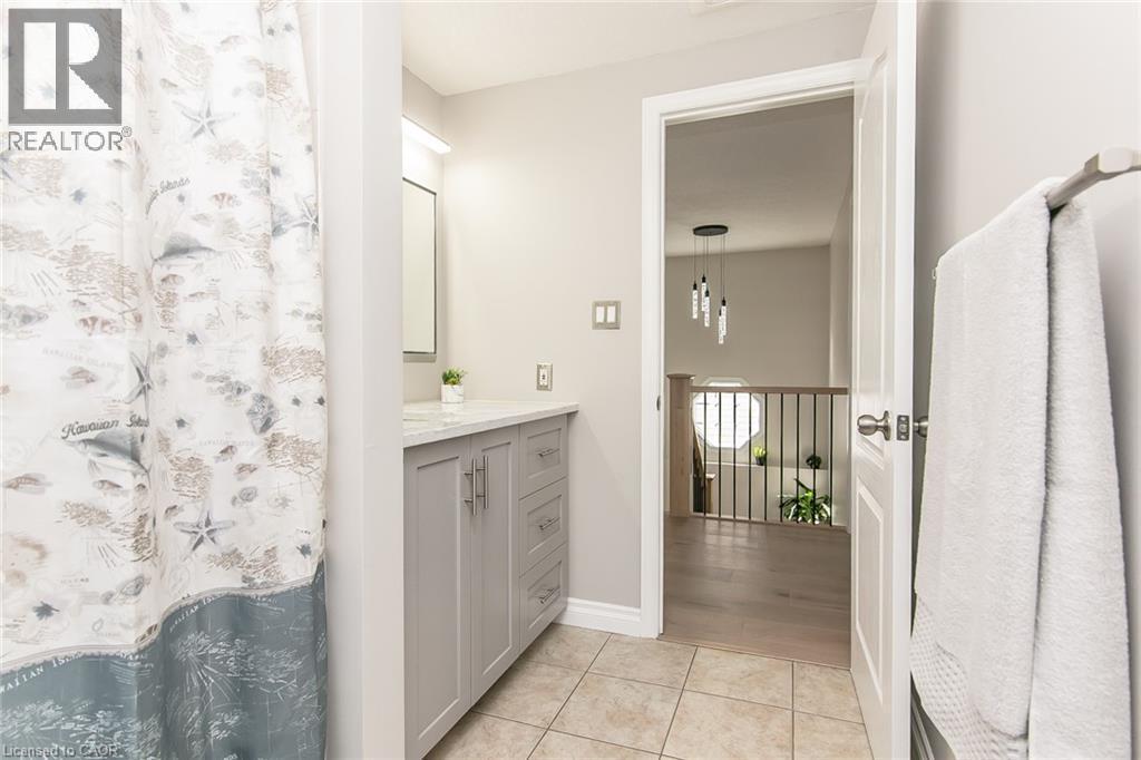 Neutral-toned bathroom featuring a single vanity with a light countertop and gray cabinetry - 529 Chesapeake Crescent, Waterloo, ON - Indoor Photo Showing Bathroom