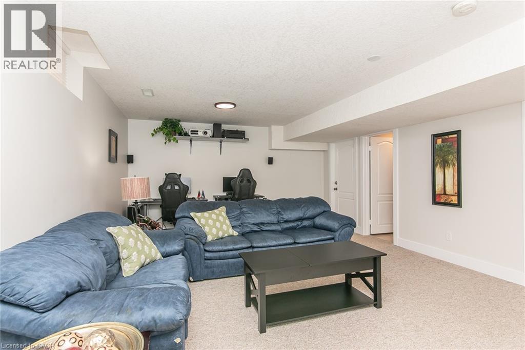 Finished lower level featuring carpet flooring, painted walls, an egress window, and a white interior door - 529 Chesapeake Crescent, Waterloo, ON - Indoor Photo Showing Living Room