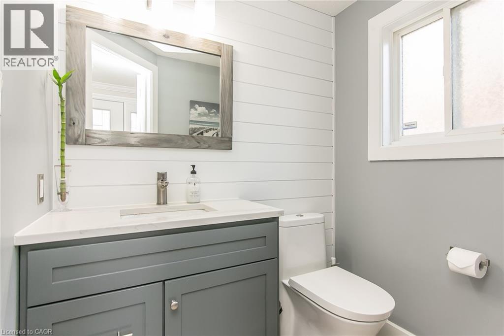 Modern bathroom featuring a contemporary vanity with a white countertop and gray cabinetry, shiplap wall accent, and a clear window - 529 Chesapeake Crescent, Waterloo, ON - Indoor Photo Showing Bathroom