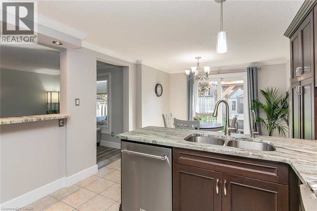 Kitchen featuring a double basin stainless steel sink, gooseneck faucet, and integrated dishwasher - 529 Chesapeake Crescent, Waterloo, ON - Indoor Photo Showing Kitchen With Double Sink