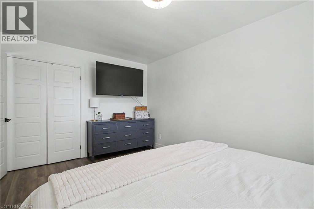 Bright interior room featuring wood-finish flooring, white walls, and a ceiling-mounted light fixture - 44 Oakhurst Crescent, Kitchener, ON - Indoor Photo Showing Bedroom
