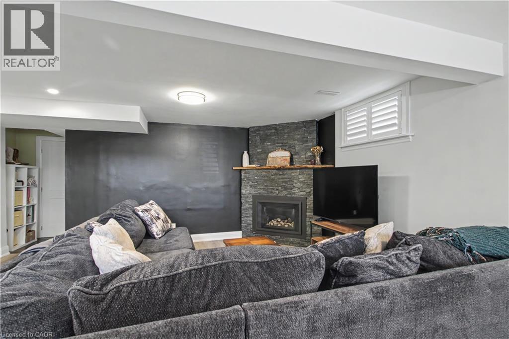 Living area featuring a floor-to-ceiling stacked stone fireplace with an integrated firebox and wood mantle - 44 Oakhurst Crescent, Kitchener, ON - Indoor With Fireplace