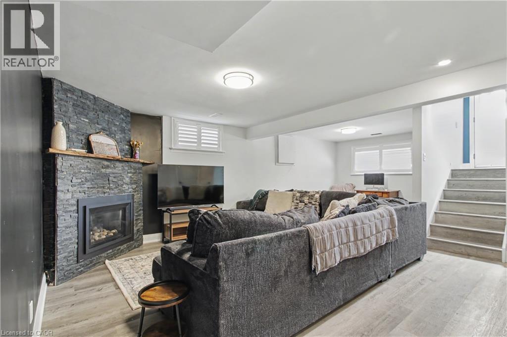 Living area featuring a stacked stone fireplace with wood mantel, light wood-finish flooring, and recessed ceiling lighting - 44 Oakhurst Crescent, Kitchener, ON - Indoor Photo Showing Living Room With Fireplace