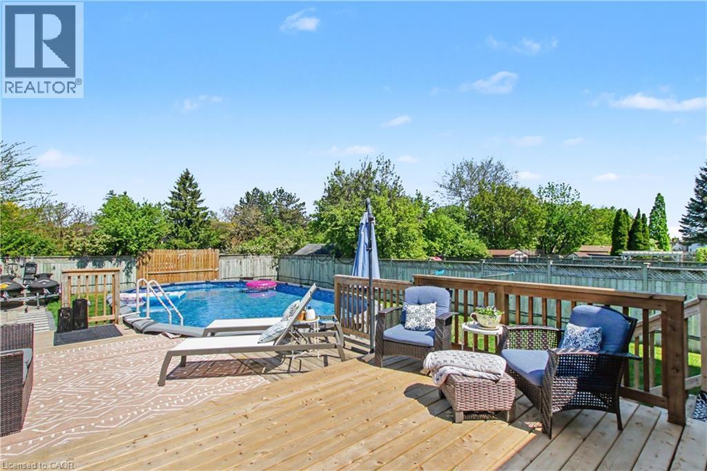 Expansive wood deck featuring a balustrade railing, providing access to an above-ground swimming pool with ladder entry - 44 Oakhurst Crescent, Kitchener, ON - Outdoor With Above Ground Pool With Deck Patio Veranda
