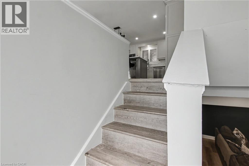 Wood-finish staircase with white risers and a white newel post - 44 Oakhurst Crescent, Kitchener, ON - Indoor Photo Showing Other Room