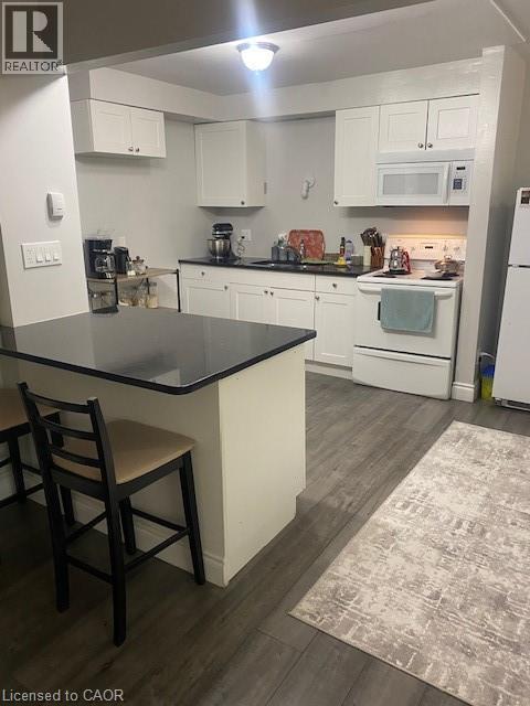 Kitchen featuring stove, dark countertops, white cabinets, and dark wood-style floors - 58 Hazelglen Drive, Kitchener, ON - Indoor Photo Showing Kitchen