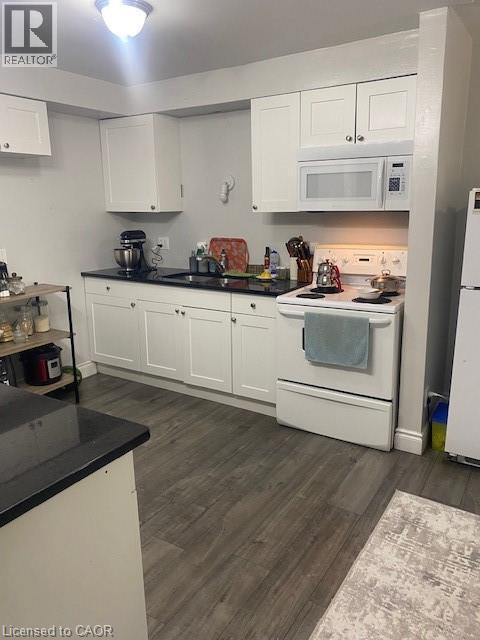 Kitchen with range, dark wood-type flooring, white cabinets, fridge, and dark countertops - 58 Hazelglen Drive, Kitchener, ON - Indoor Photo Showing Kitchen With Double Sink