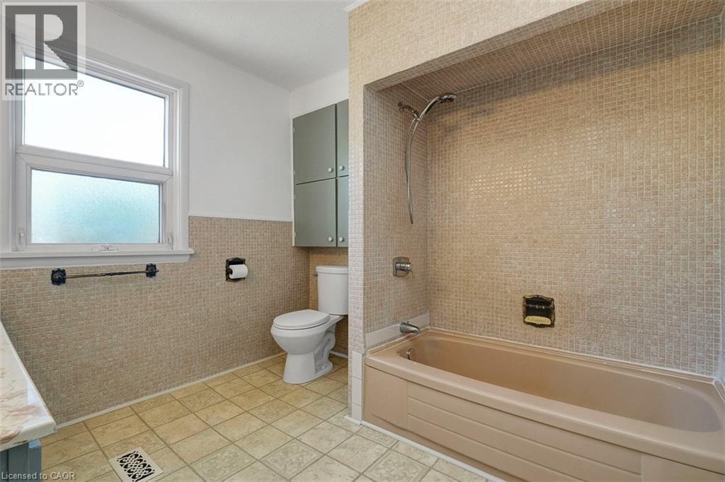 Full bathroom featuring a built-in tub and shower with mosaic tile surround - 14 Niagara Street, Hamilton, ON