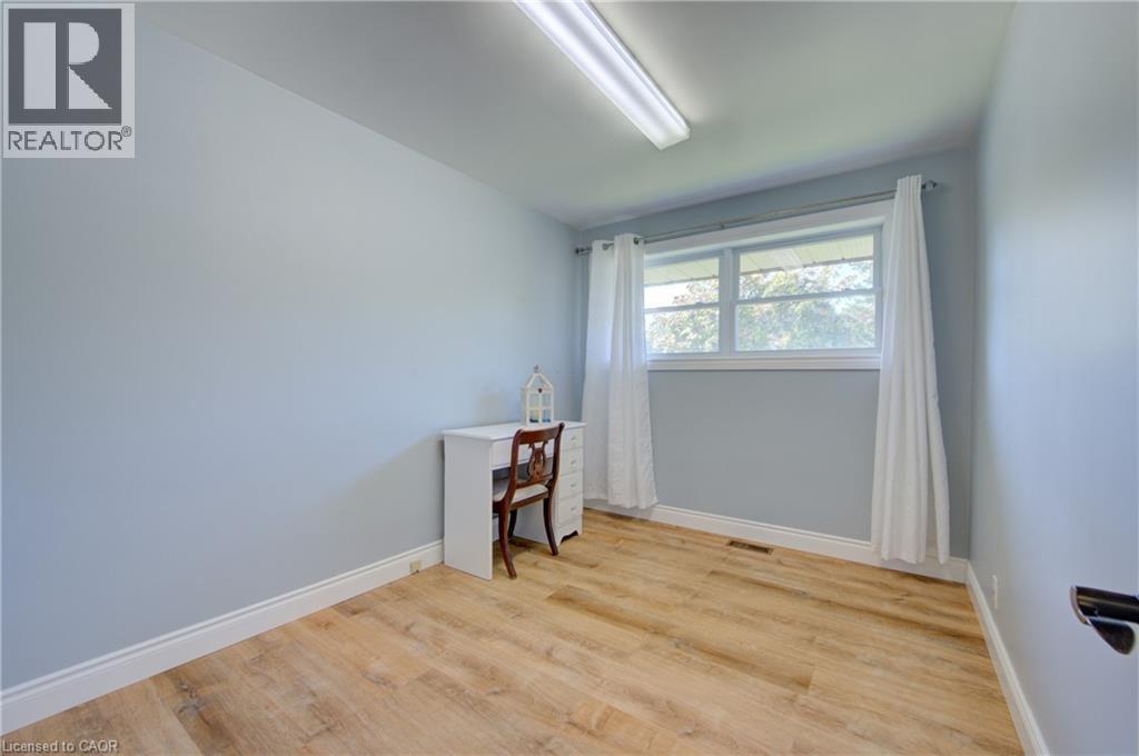 Bright room featuring light blue walls, wood-finish flooring, and white baseboards - 251 Union Street E, Waterloo, ON