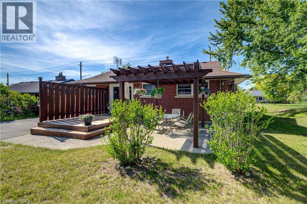 Rear elevation featuring a brick exterior and a tiered wood deck with privacy fencing - 251 Union Street E, Waterloo, ON