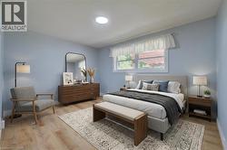 Bedroom with wood-finish flooring, light blue walls, and a recessed ceiling light -