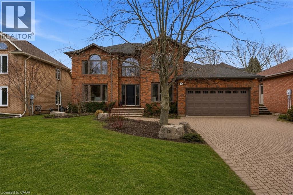Brick exterior residential property featuring a paver driveway, an integrated two-car garage, and arched windows - 28 Deerview Avenue, Ancaster, ON