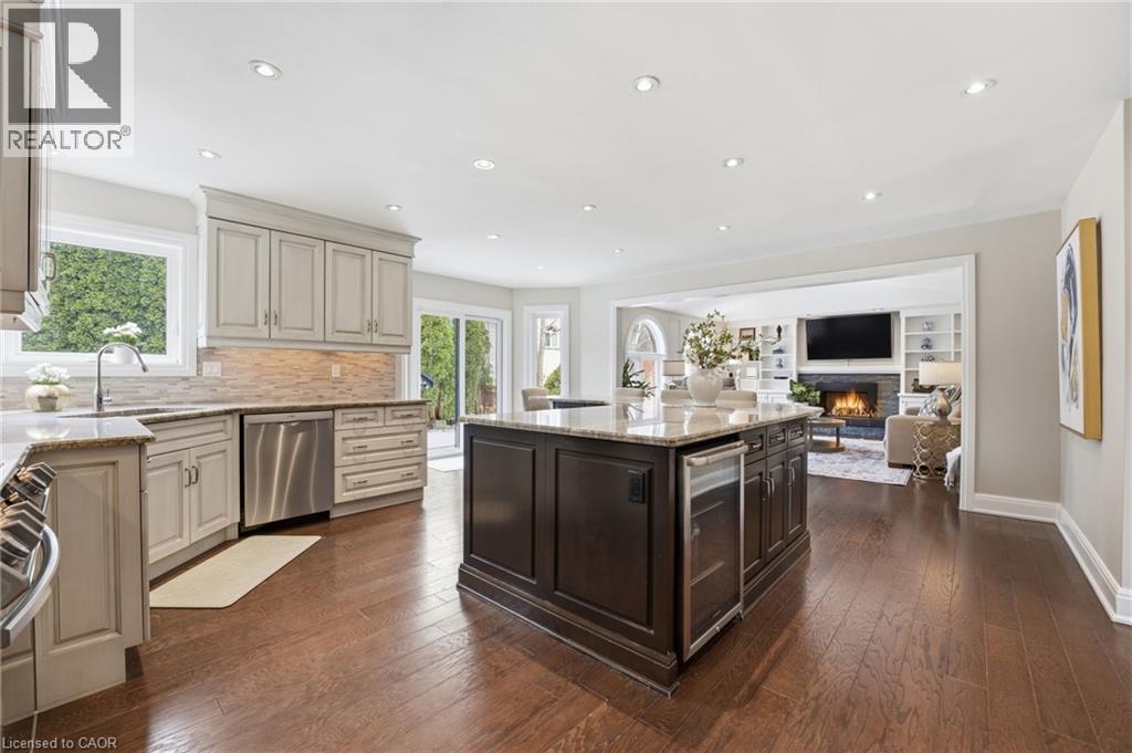 Kitchen featuring light stone counters, open floor plan, wine cooler, stainless steel appliances, and recessed lighting - 28 Deerview Avenue, Ancaster, ON