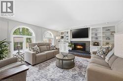 Living area featuring a fireplace, built in shelves, and wood finished floors -