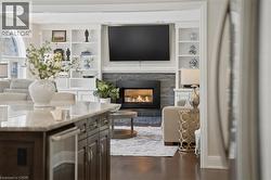 Living room with built in features, a fireplace, and dark wood-type flooring -