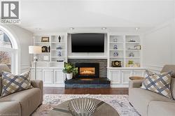 Living area featuring built in shelves, dark wood finished floors, a fireplace, and lofted ceiling -