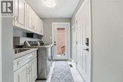 Laundry area with washing machine and dryer, cabinet space, and light tile patterned floors -