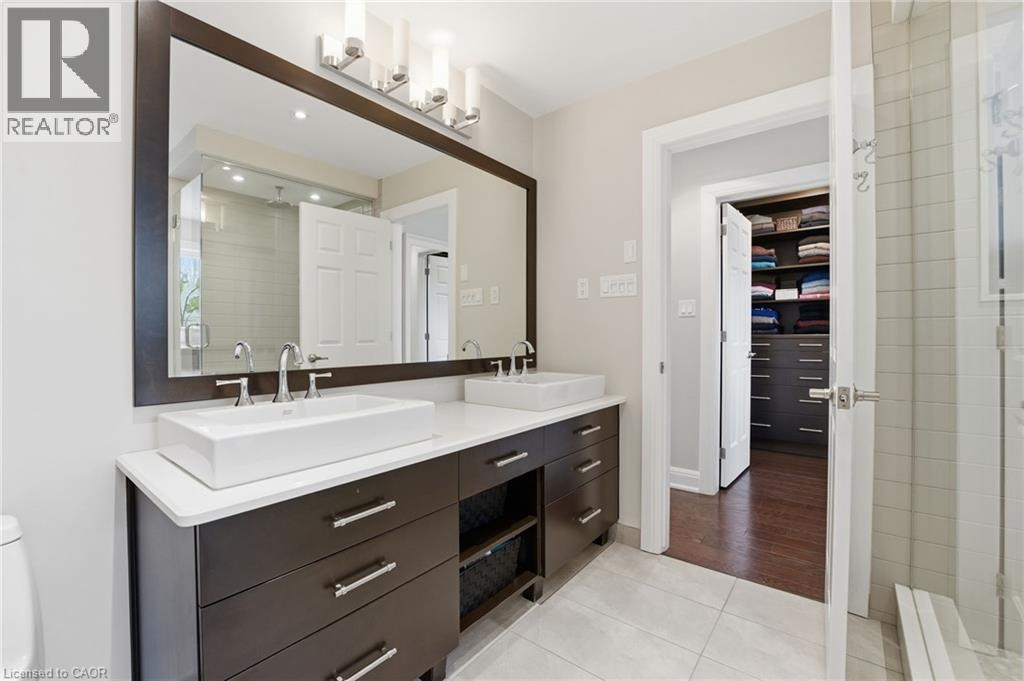 Bathroom with double vanity, light tile patterned flooring, and a stall shower - 28 Deerview Avenue, Ancaster, ON