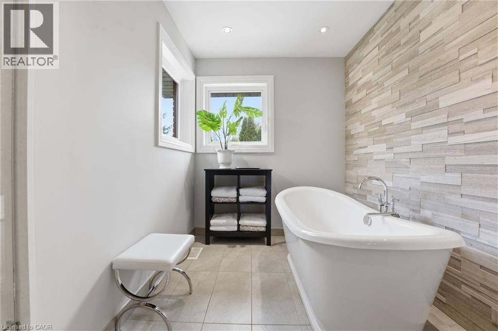Full bathroom featuring an accent wall, a soaking tub, recessed lighting, and light tile patterned flooring - 28 Deerview Avenue, Ancaster, ON