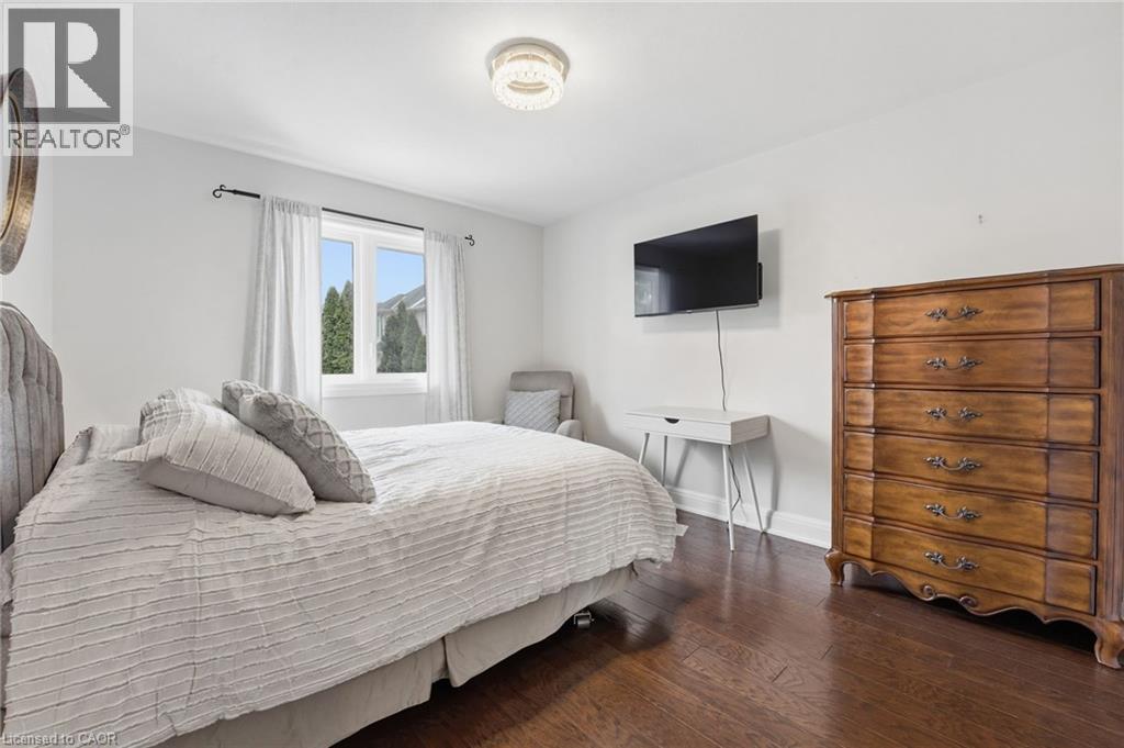 Bedroom featuring dark wood-style floors and baseboards - 28 Deerview Avenue, Ancaster, ON