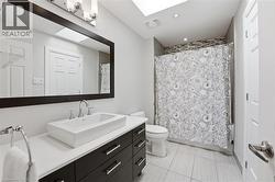Bathroom with vanity, a skylight, shower / bath combo, and light tile patterned floors -