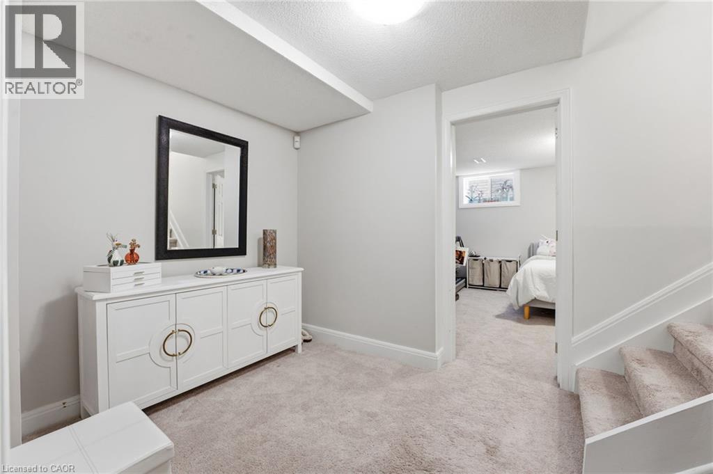 Bedroom featuring light colored carpet and a textured ceiling - 28 Deerview Avenue, Ancaster, ON