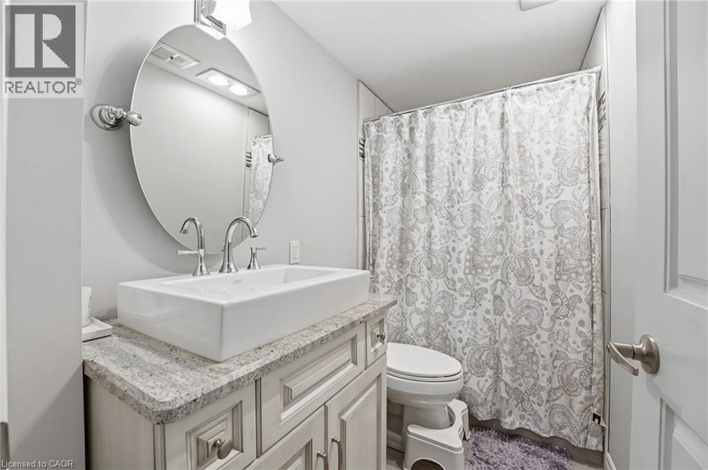 Bathroom with vanity and a shower with shower curtain - 28 Deerview Avenue, Ancaster, ON