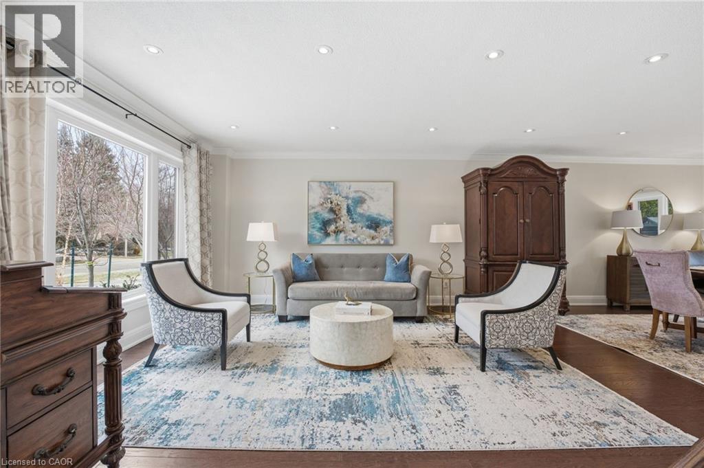 Living area featuring crown molding, dark wood finished floors, and recessed lighting - 28 Deerview Avenue, Ancaster, ON