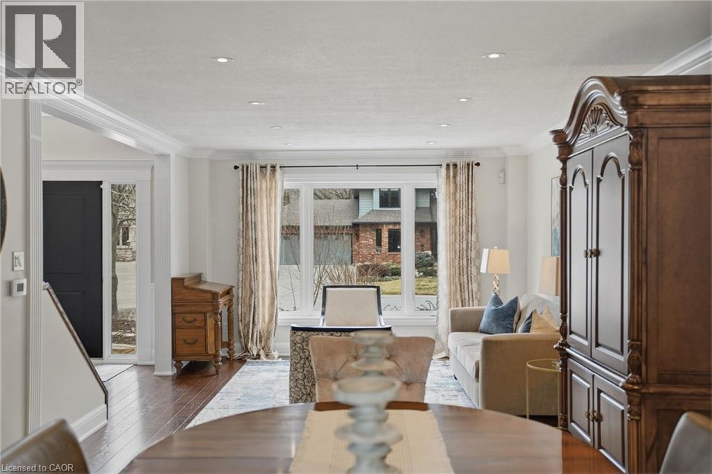 Dining space with ornamental molding and dark wood finished floors - 28 Deerview Avenue, Ancaster, ON