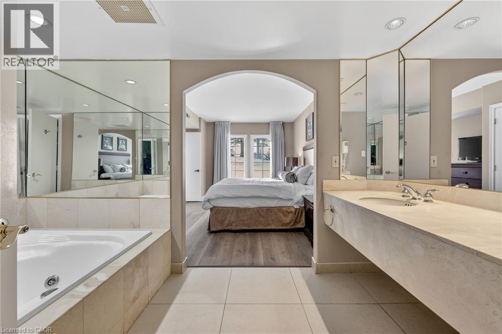 Ensuite bathroom with vanity, a jetted tub, light tile patterned floors, and recessed lighting - 90 Highland Drive Unit# 2014/15, Simcoe, ON