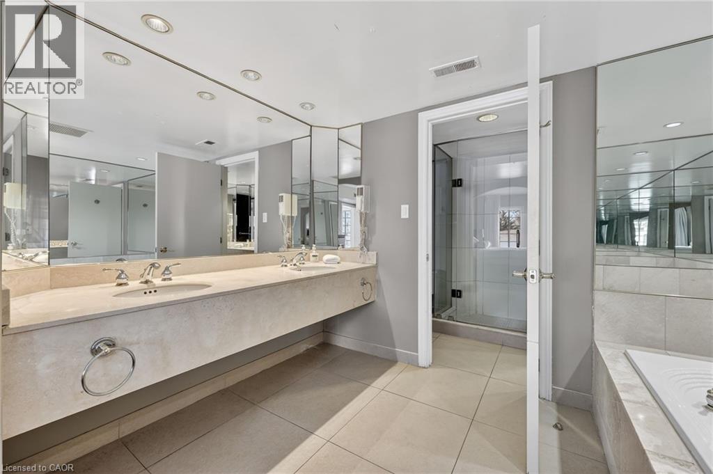 Full bathroom featuring double vanity, a garden tub, a stall shower, light tile patterned floors, and recessed lighting - 90 Highland Drive Unit# 2014/15, Simcoe, ON