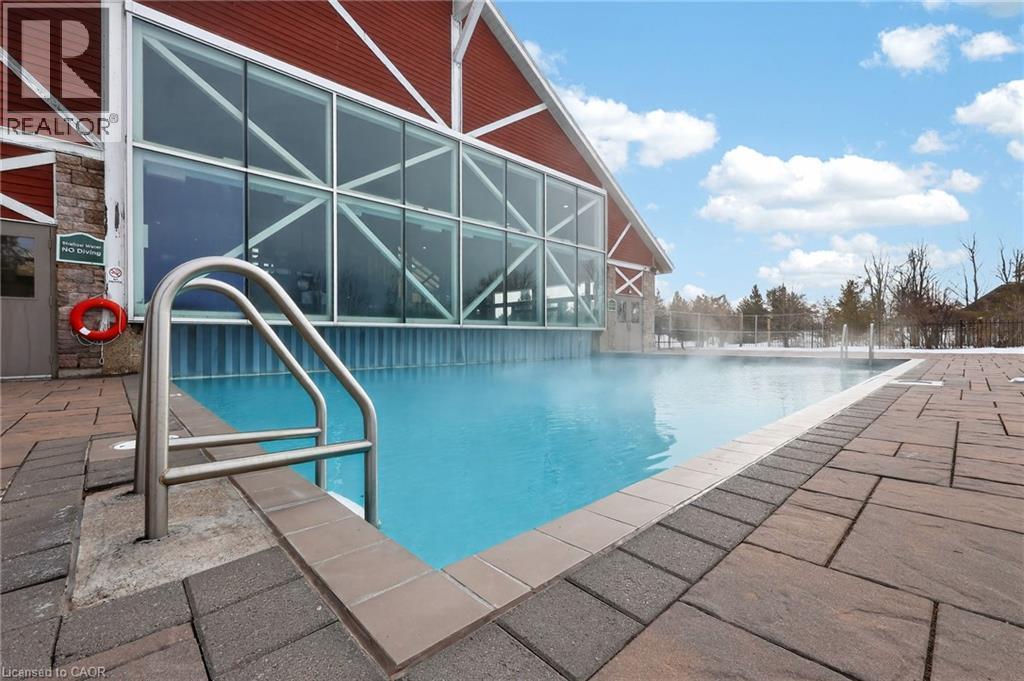 Community pool featuring a patio area and glass enclosure - 90 Highland Drive Unit# 2014/15, Simcoe, ON