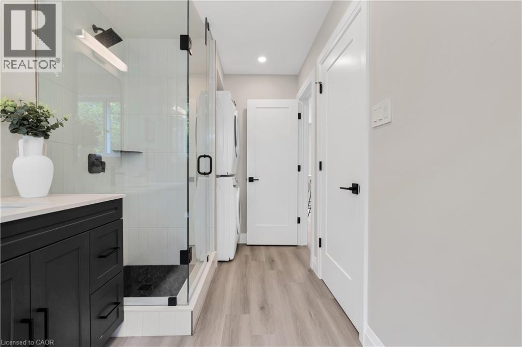 Modern bathroom featuring a glass-enclosed shower with a rainfall showerhead and black hardware - 71 Blucher Street Unit# G, Kitchener, ON