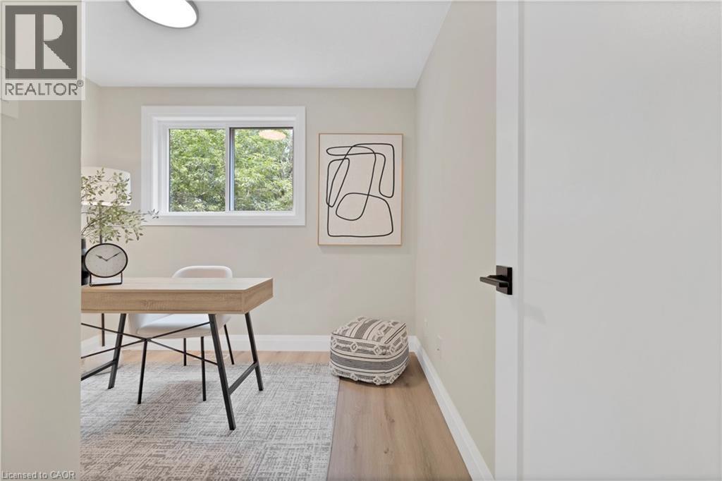 Bright room with a large window, light wood-finish flooring, and a modern white door with matte black hardware - 71 Blucher Street Unit# G, Kitchener, ON