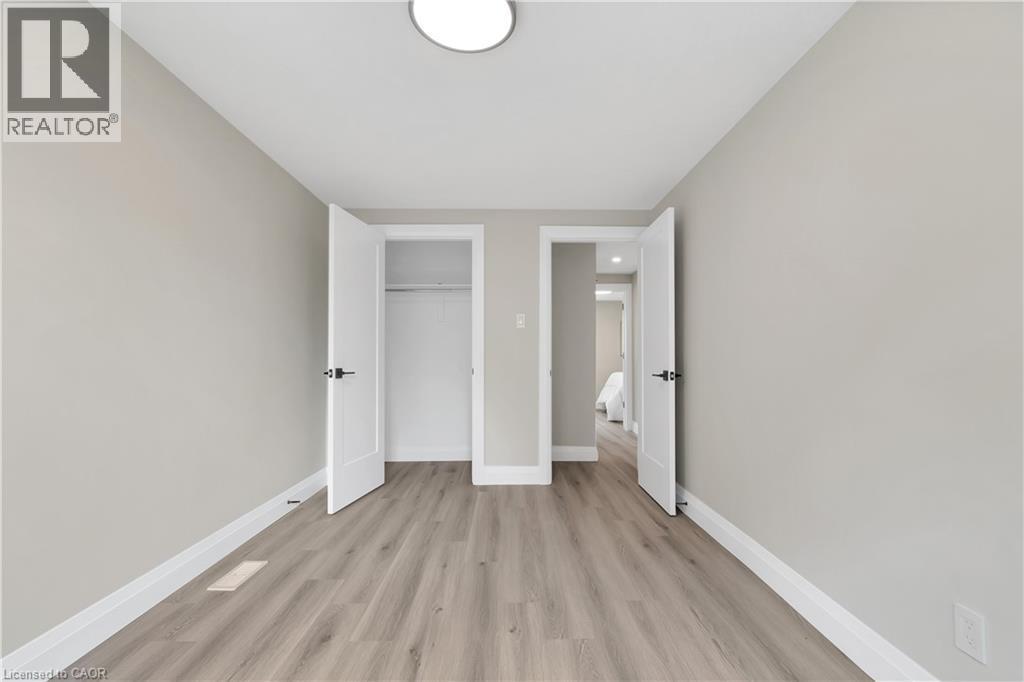 Room featuring wood-finish flooring and neutral wall tones - 71 Blucher Street Unit# G, Kitchener, ON