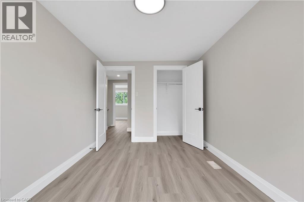 Neutrally painted room featuring wood-finish flooring, white trim, and recessed lighting - 71 Blucher Street Unit# G, Kitchener, ON