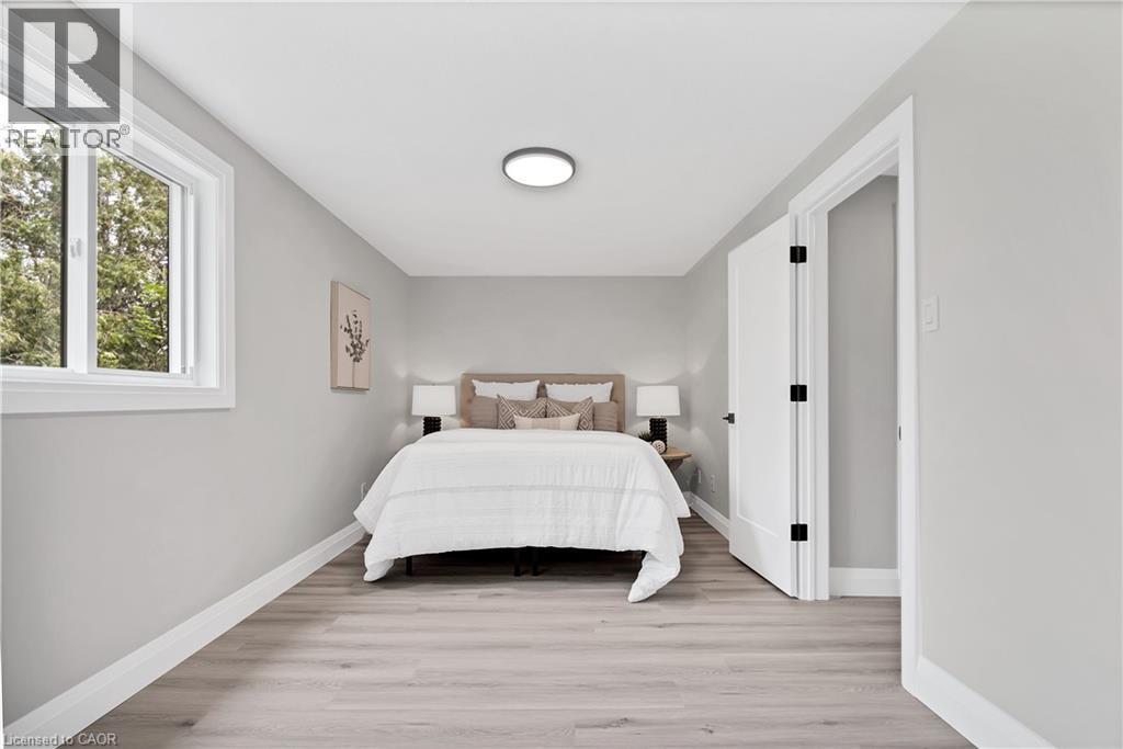 Bedroom featuring light wood-finish flooring, crisp white baseboards, and a single pane window with white trim - 71 Blucher Street Unit# G, Kitchener, ON