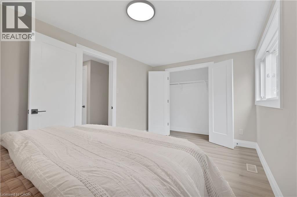 Light gray walls with white trim, wood-finish flooring, and a flush-mount ceiling light fixture - 71 Blucher Street Unit# G, Kitchener, ON