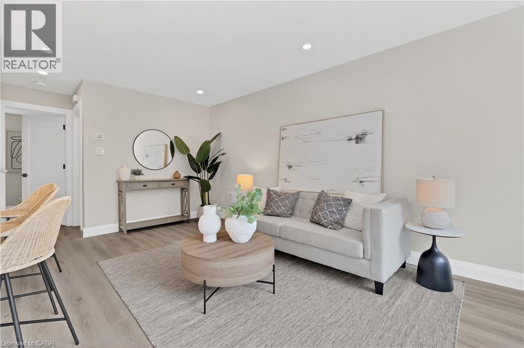 Open-concept living area featuring light wood-finish flooring, recessed lighting, and neutral wall tones - 71 Blucher Street Unit# G, Kitchener, ON