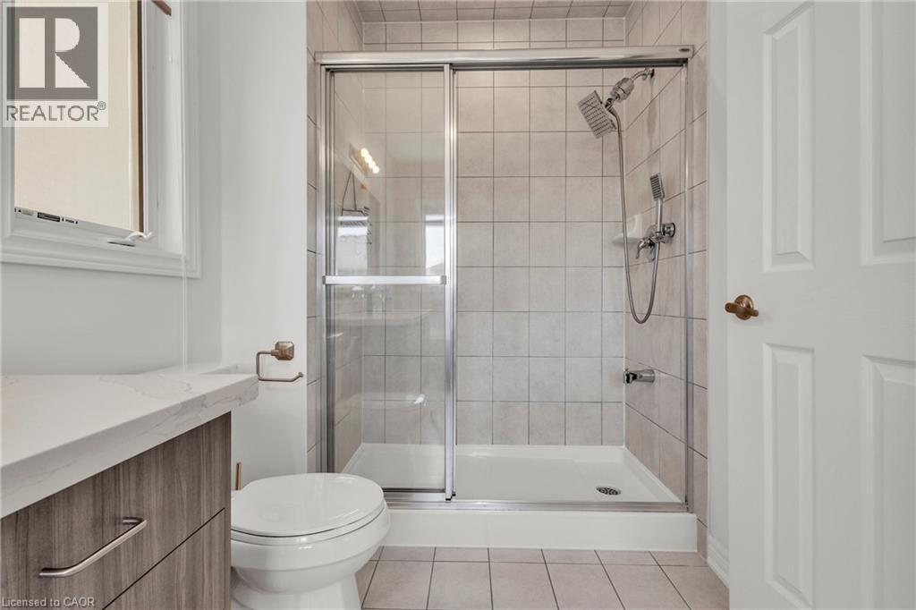 Bathroom featuring a glass-enclosed shower with tile surround, a rain shower head, and a hand shower - 101 Westfield Crescent, Waterdown, ON