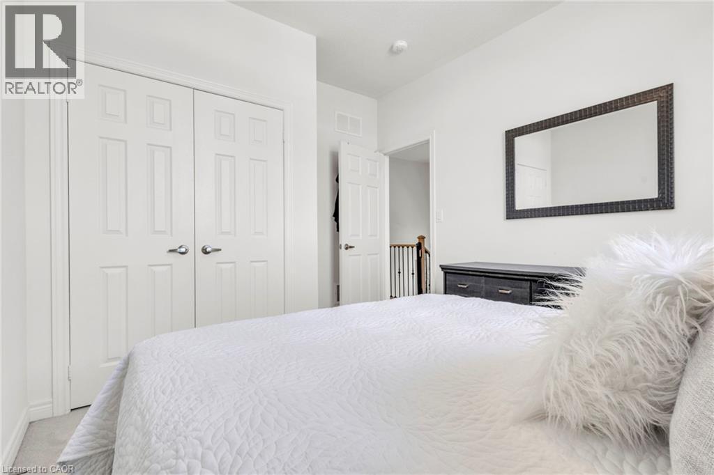 Bedroom2- featuring light-colored carpet flooring, white walls, and a two-door panel closet with brushed nickel hardware - 101 Westfield Crescent, Waterdown, ON