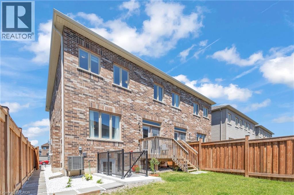 Brick exterior featuring multiple windows and a rear wooden deck - 101 Westfield Crescent, Waterdown, ON