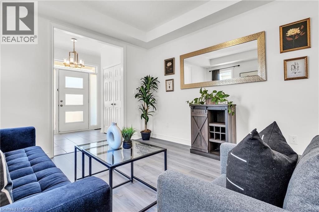 Living and Foyer-Light-filled entry area featuring a modern front door with frosted glass panels, a contemporary chandelier, and tiled flooring - 101 Westfield Crescent, Waterdown, ON