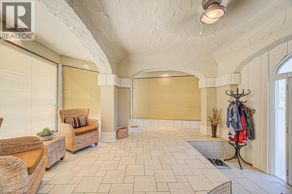 Tiled flooring throughout this versatile interior space featuring arched ceilings, recessed lighting, and expansive windows fitted with blinds - 2032 Coronation Boulevard, Cambridge, ON - Indoor Photo Showing Other Room