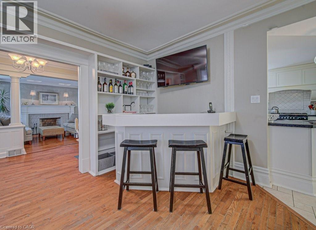 Built-in bar featuring integrated open shelving, panel detailing, and a wall-mounted display - 2032 Coronation Boulevard, Cambridge, ON - Indoor Photo Showing Other Room