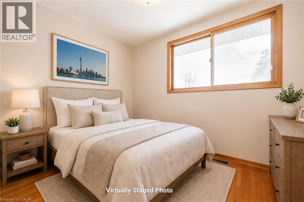 Room featuring wood-finish flooring, a neutral wall color, and a large window with wood trim - 66 Summit Avenue, Kitchener, ON - Indoor Photo Showing Bedroom