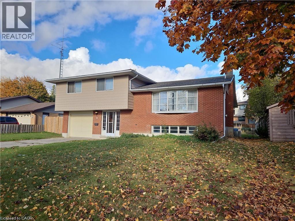Brick and siding exterior featuring an attached garage with a light-colored door - 66 Summit Avenue, Kitchener, ON - Outdoor