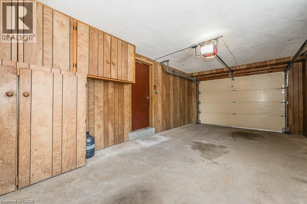 Attached garage featuring wood-paneled walls and built-in cabinetry - 66 Summit Avenue, Kitchener, ON - Indoor Photo Showing Garage